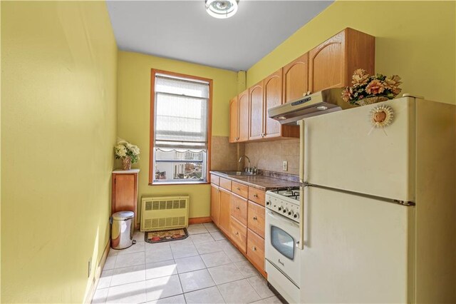 kitchen featuring light brown cabinetry, tasteful backsplash, sink, light tile patterned floors, and white appliances