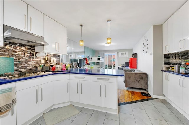 kitchen featuring tasteful backsplash, stainless steel gas stovetop, light tile patterned floors, white cabinets, and hanging light fixtures