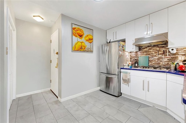 kitchen with appliances with stainless steel finishes, backsplash, white cabinetry, and light tile patterned floors