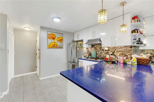 kitchen featuring sink, stainless steel appliances, pendant lighting, decorative backsplash, and white cabinets