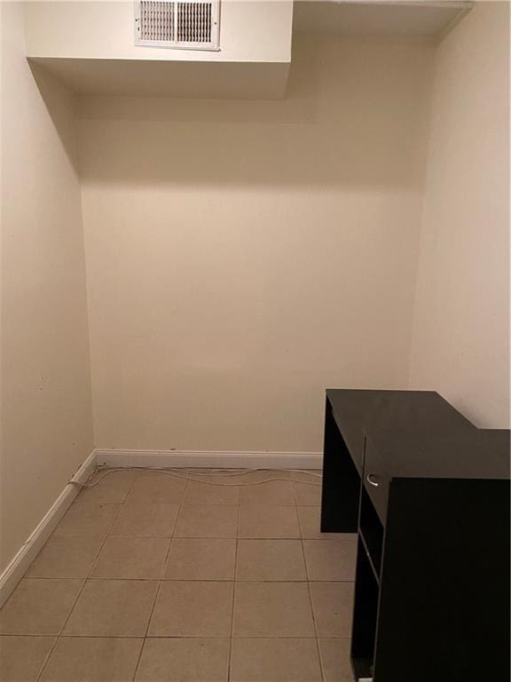 laundry area with light tile patterned floors