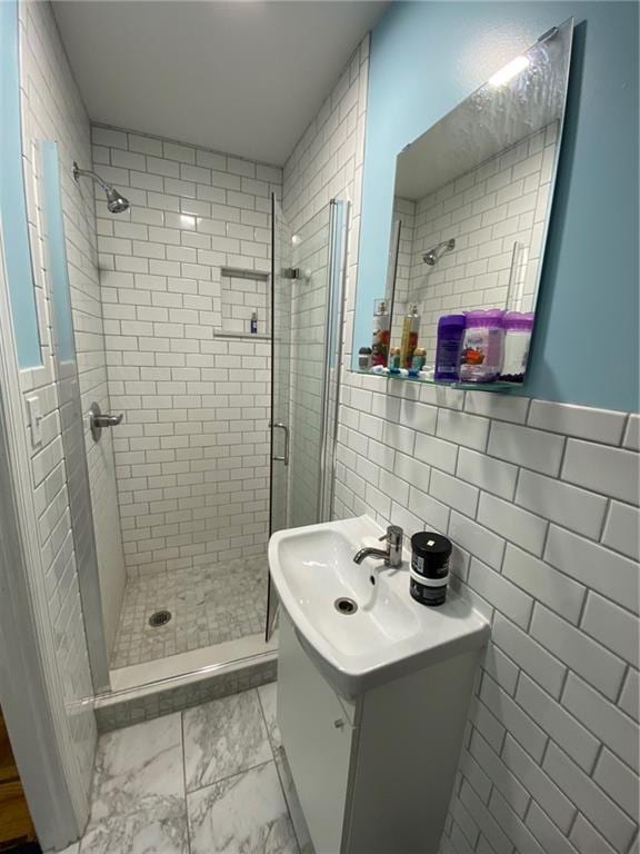 bathroom featuring vanity, walk in shower, and tile walls