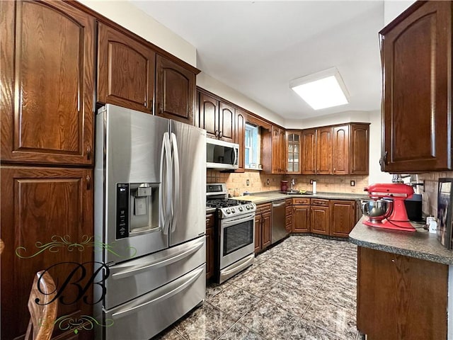 kitchen featuring decorative backsplash, appliances with stainless steel finishes, and sink