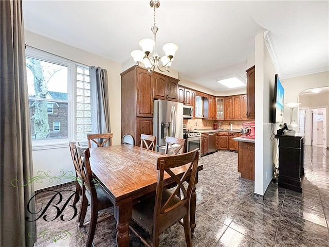 dining space featuring crown molding and an inviting chandelier