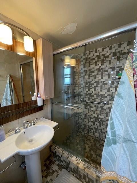 bathroom featuring a shower with shower door and tile patterned floors