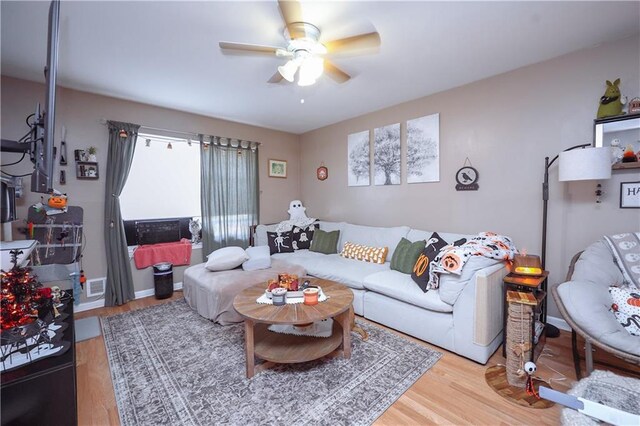 living room with light hardwood / wood-style floors and ceiling fan