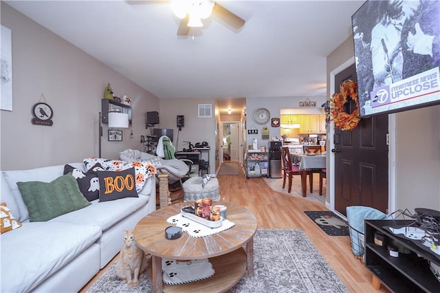 living room featuring light wood-type flooring and ceiling fan