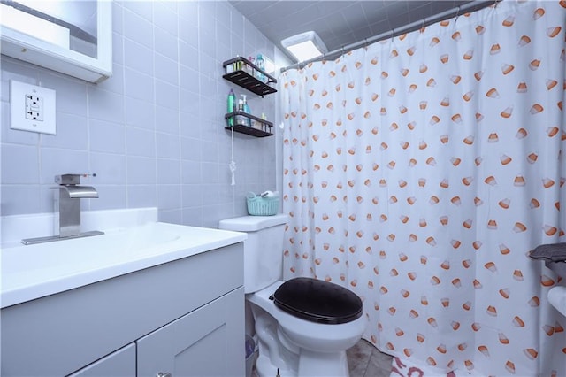 bathroom featuring vanity, tile walls, toilet, and curtained shower