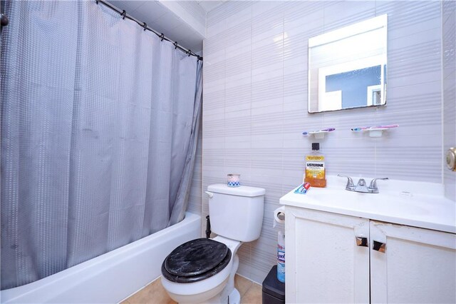 full bathroom featuring vanity, shower / tub combo, tile patterned floors, tile walls, and toilet