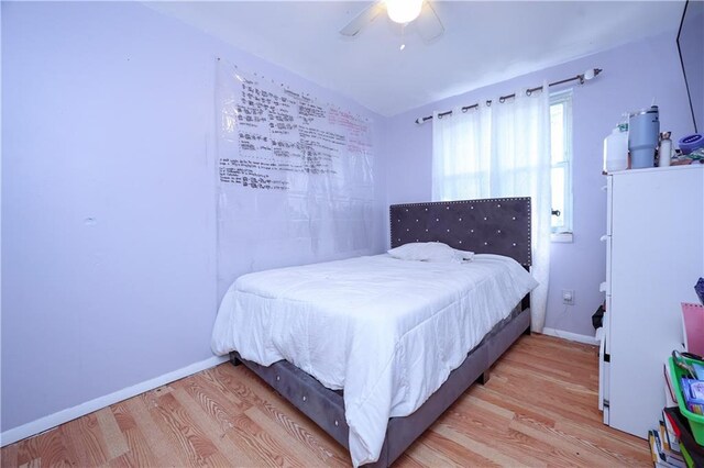 bedroom featuring wood-type flooring, vaulted ceiling, and ceiling fan