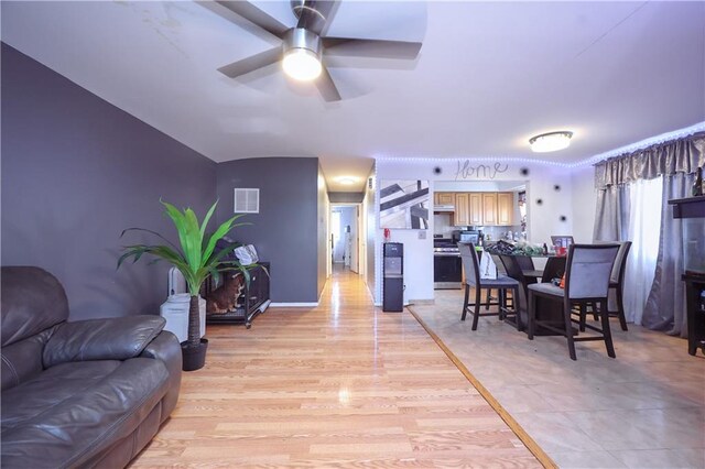 dining space with light wood-type flooring and ceiling fan