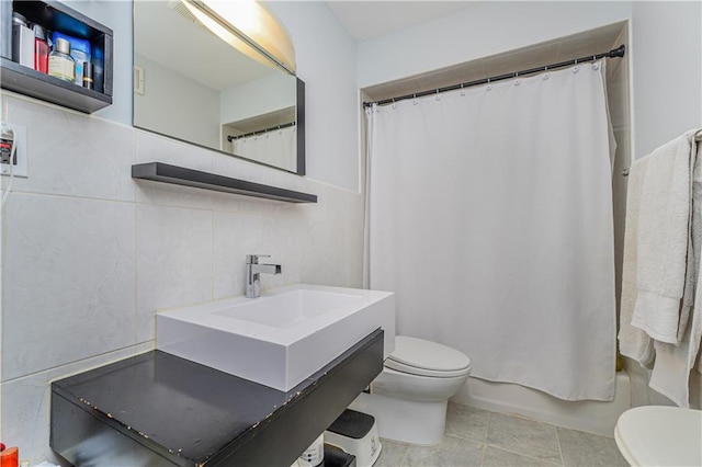 full bathroom with tile patterned floors, toilet, shower / tub combo, vanity, and tile walls