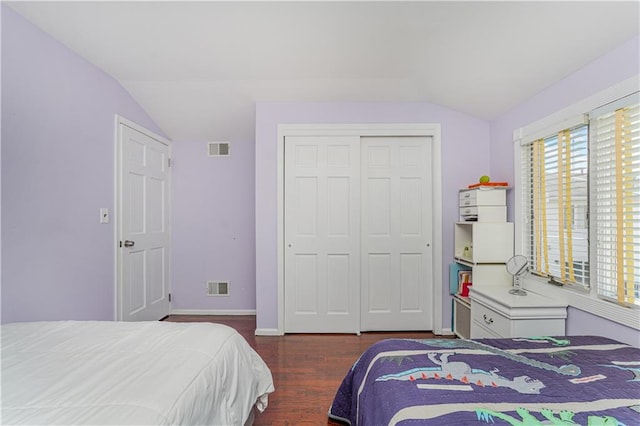 bedroom featuring a closet, lofted ceiling, and dark hardwood / wood-style flooring