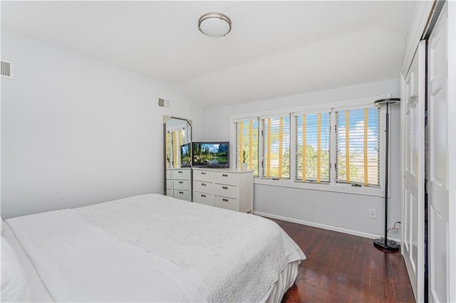 bedroom with lofted ceiling and dark hardwood / wood-style floors