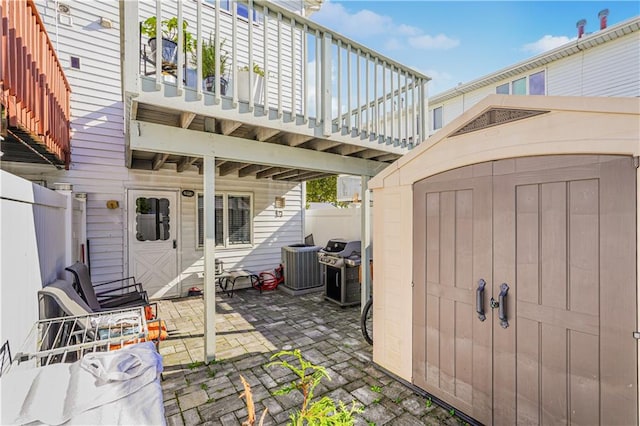 view of patio / terrace featuring a storage unit, central AC unit, and grilling area