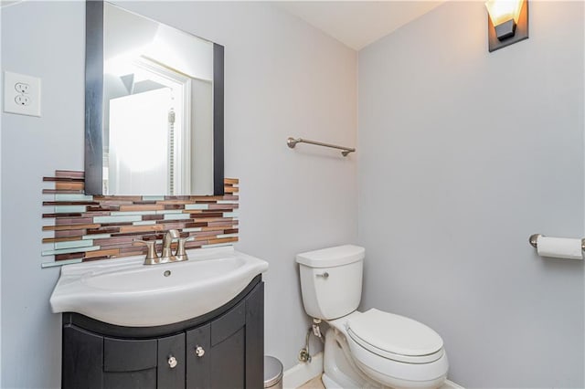 bathroom with toilet, decorative backsplash, and vanity