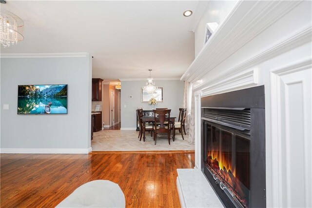 dining space featuring hardwood / wood-style floors, crown molding, and an inviting chandelier