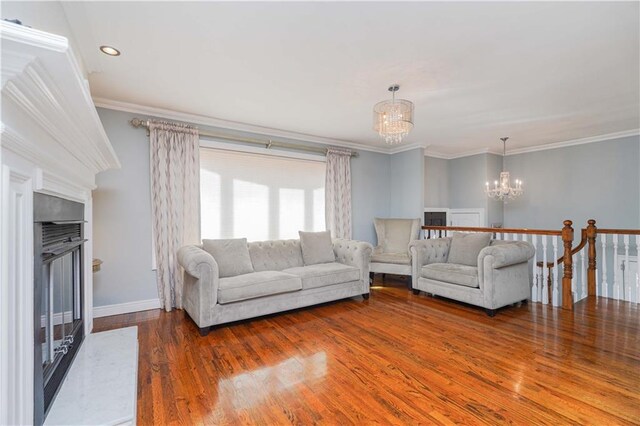 unfurnished living room featuring crown molding, hardwood / wood-style flooring, and a notable chandelier