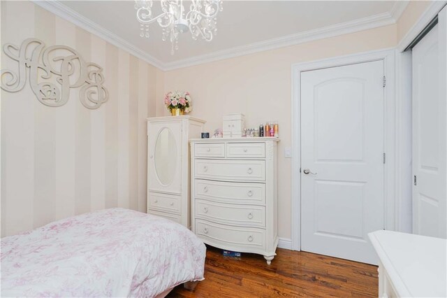 bedroom with dark wood-type flooring, a closet, crown molding, and a notable chandelier