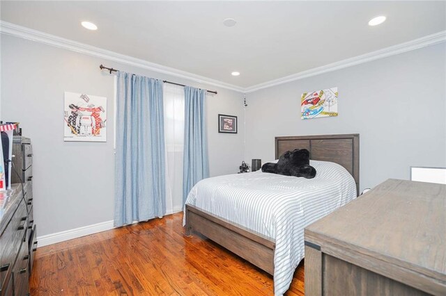 bedroom with hardwood / wood-style floors and ornamental molding