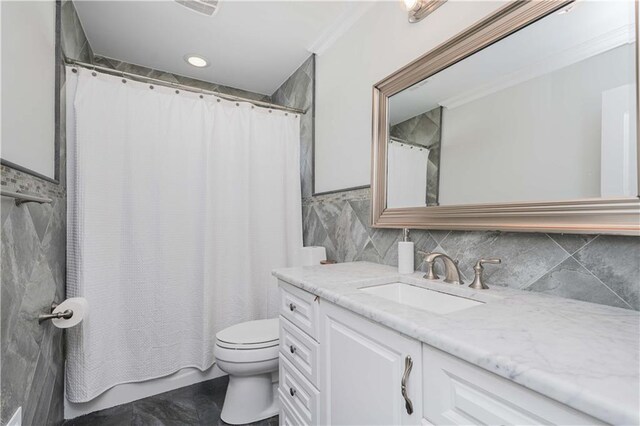 bathroom with toilet, ornamental molding, and vanity