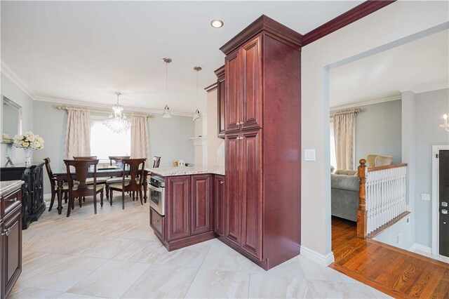 kitchen with decorative light fixtures, light stone countertops, ornamental molding, and a notable chandelier