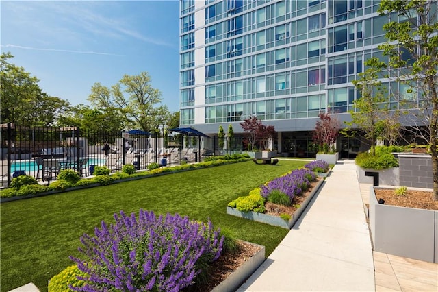 view of property's community with a swimming pool and a yard