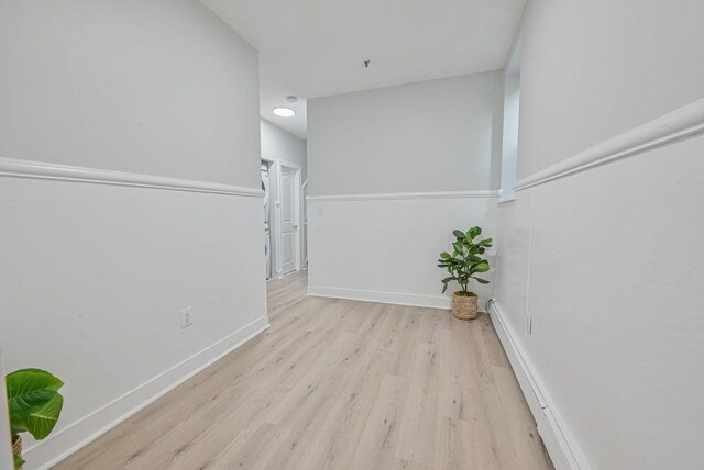 hallway with baseboards and wood finished floors