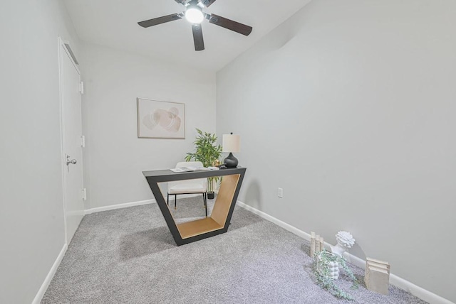 carpeted office with a ceiling fan and baseboards