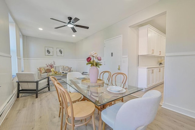 dining space featuring a baseboard heating unit, ceiling fan, and light hardwood / wood-style flooring