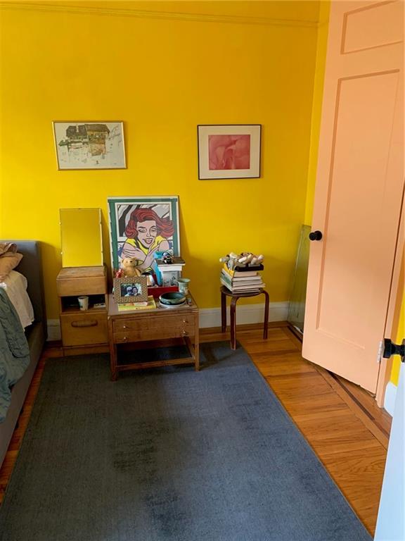 living area with hardwood / wood-style flooring and ornamental molding