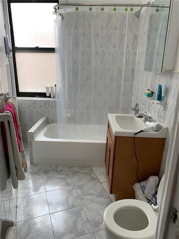 full bathroom with shower / tub combination, vanity, toilet, and tile walls