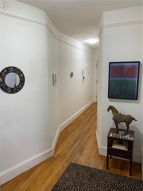 hallway with hardwood / wood-style flooring