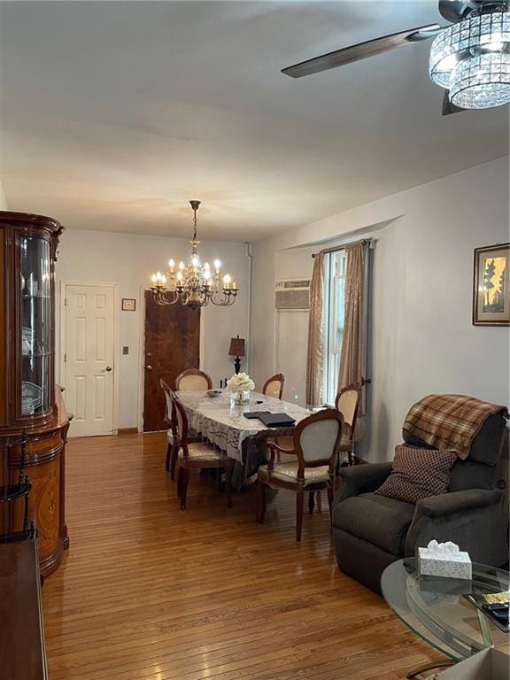 dining room featuring wood-type flooring and ceiling fan with notable chandelier