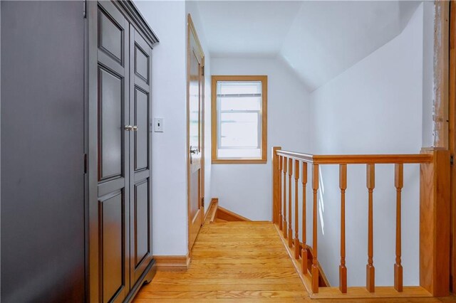 corridor featuring lofted ceiling and light wood-type flooring