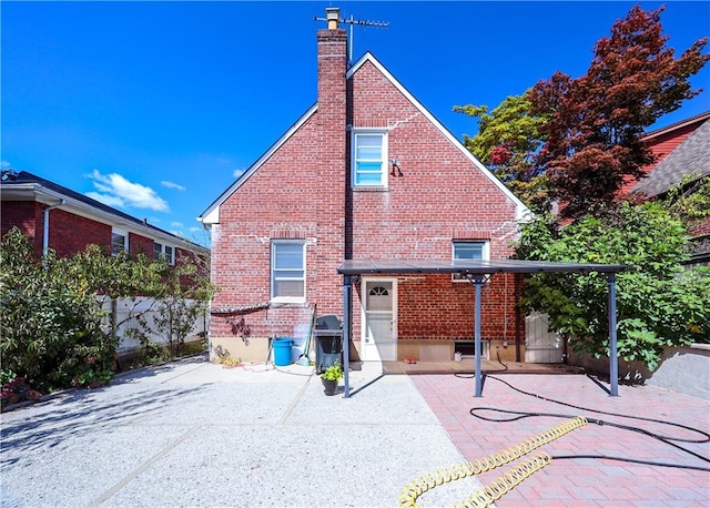 back of house with brick siding, a patio, and fence