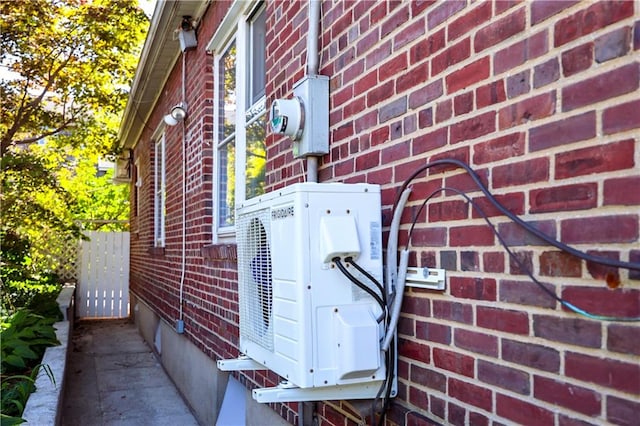 view of side of home with brick siding and ac unit