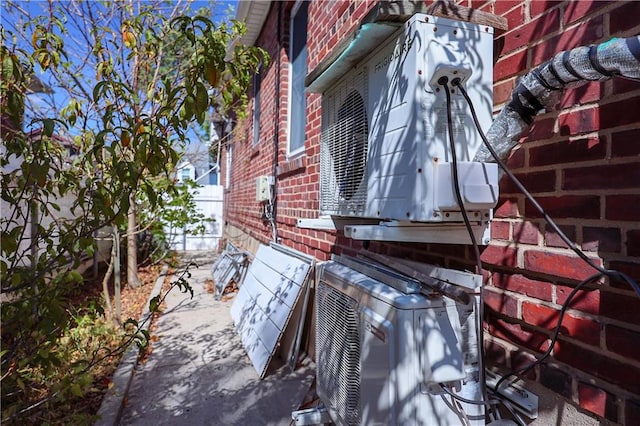 view of side of home with ac unit and brick siding