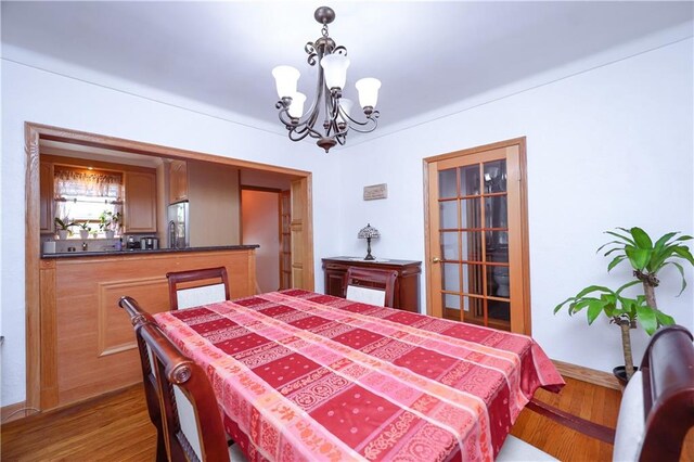 dining room featuring wood-type flooring and an inviting chandelier