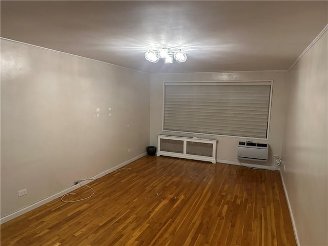 spare room with hardwood / wood-style floors, radiator heating unit, crown molding, and a wall mounted AC