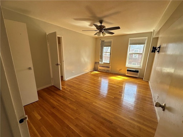 spare room featuring wood-type flooring, radiator, heating unit, and ceiling fan