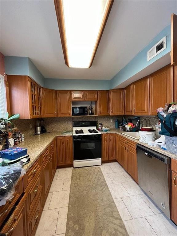 kitchen featuring light stone counters, dishwasher, white range, and tasteful backsplash