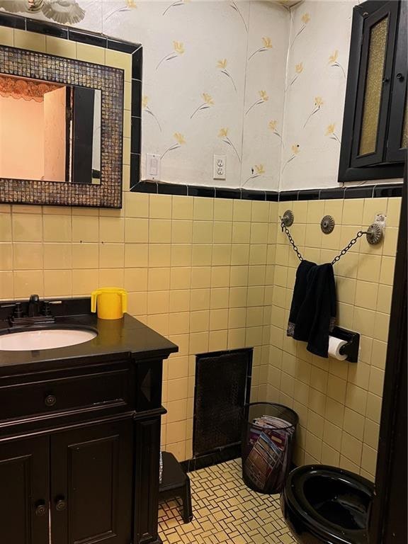 bathroom with vanity and tile walls