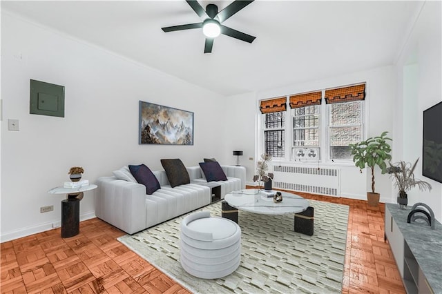 living room featuring electric panel, ceiling fan, radiator heating unit, and light parquet flooring