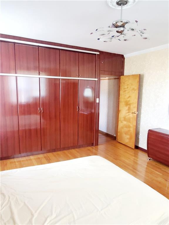 unfurnished bedroom with light wood-type flooring, a closet, and crown molding