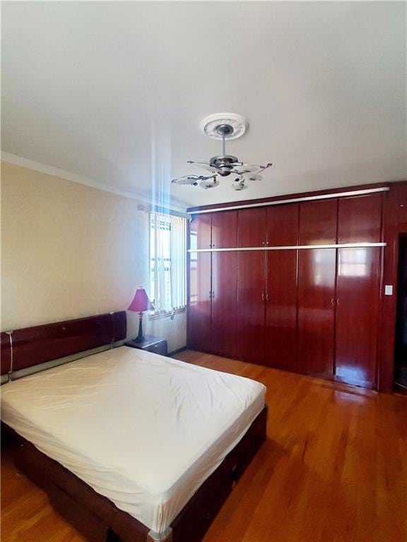 bedroom with ornamental molding and hardwood / wood-style floors