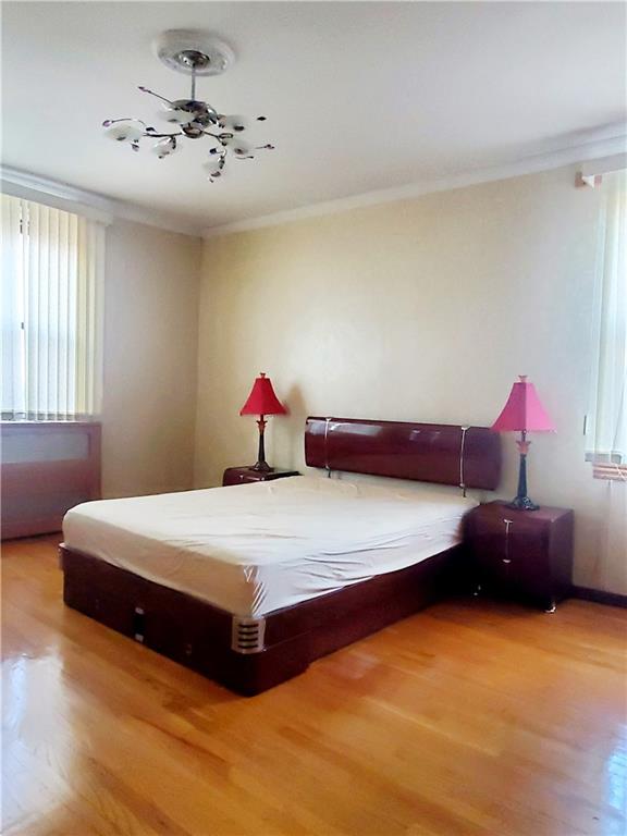 bedroom featuring hardwood / wood-style floors and ornamental molding