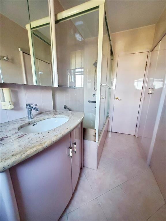 bathroom with vanity, tile patterned floors, an enclosed shower, and backsplash