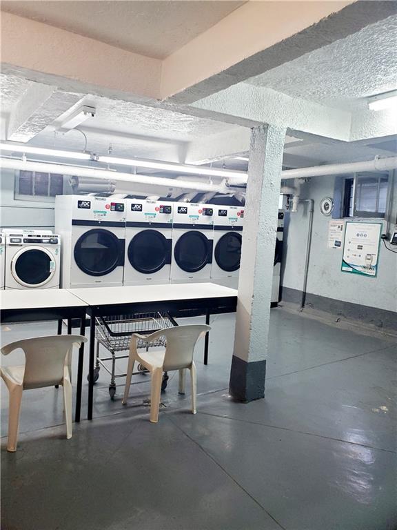 washroom with a textured ceiling and independent washer and dryer