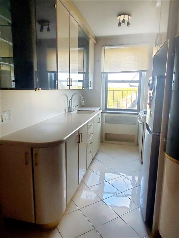 kitchen with stainless steel range oven, light tile patterned floors, and sink